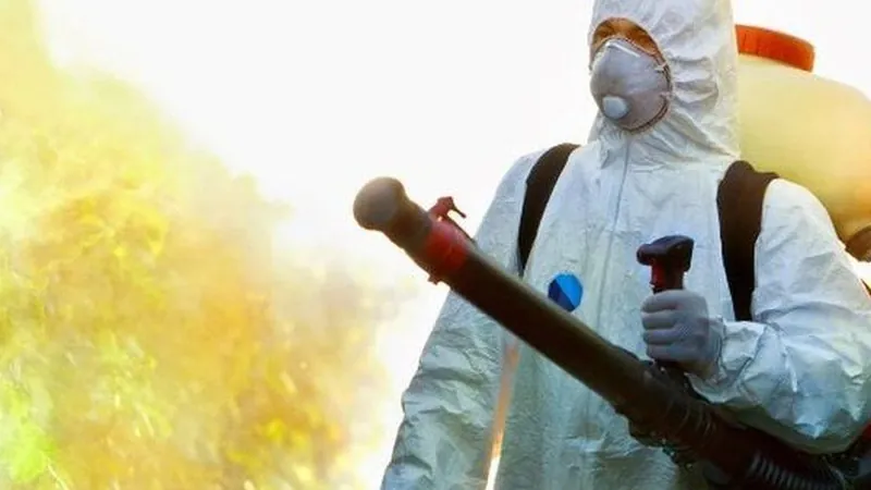 Técnico con equipo de protección junto a un pino tratado contra la procesionaria