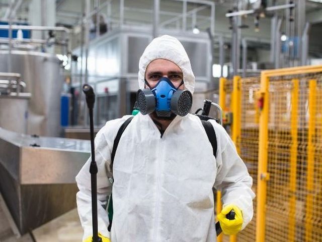 Técnico con máscara y buzo en una planta de producción de acero inoxidable