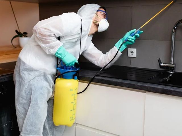 Técnico con EPI tratando la zona de fregaderos de un local de hostelería